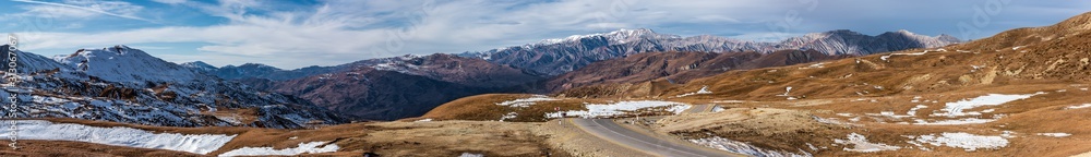 Wide panoramic view to mountain tops covered with snow