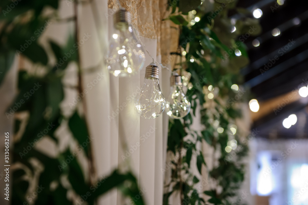 close up photo of a hanging row of light bulbs on the wall in a banquet hall