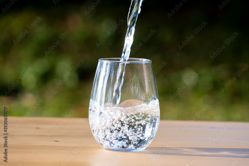 Pouring pure water in to the glass make spread of water crystal bubble with background nature Pouring pure water in to the glass make spread of water crystal bubble with background nature