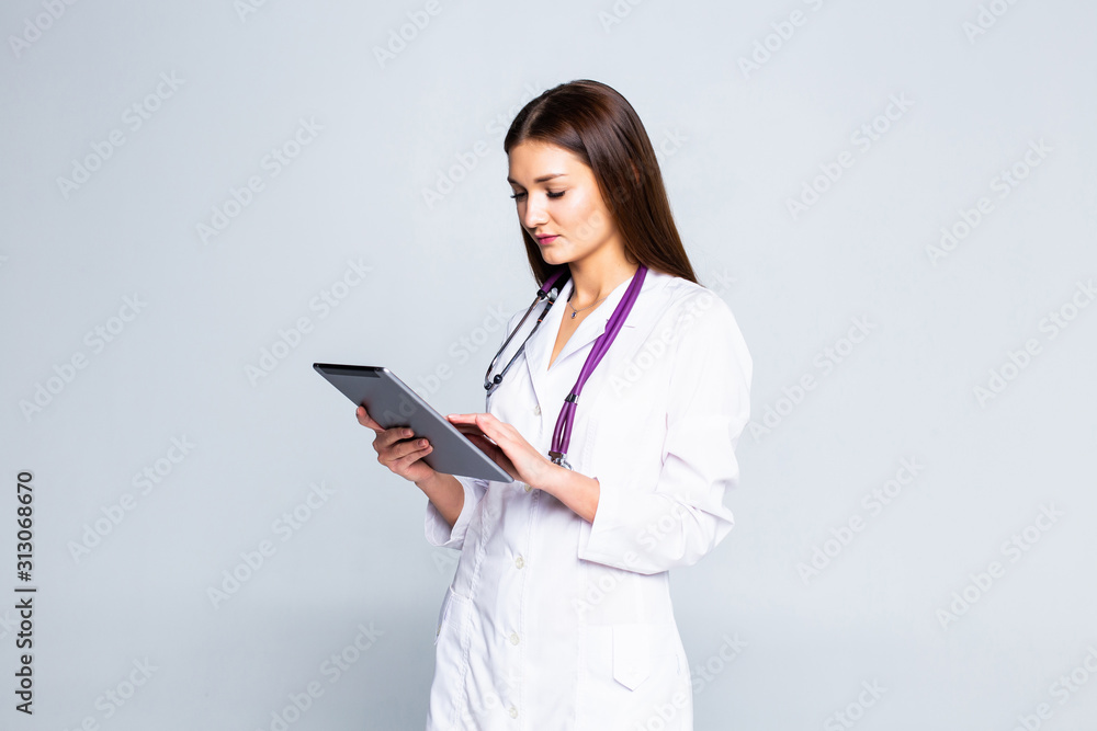 Doctor using a tablet computer isolated over a white background Doctor using a tablet computer isolated over a white background