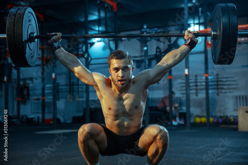Bild auf Leinwand Caucasian man practicing in weightlifting in gym