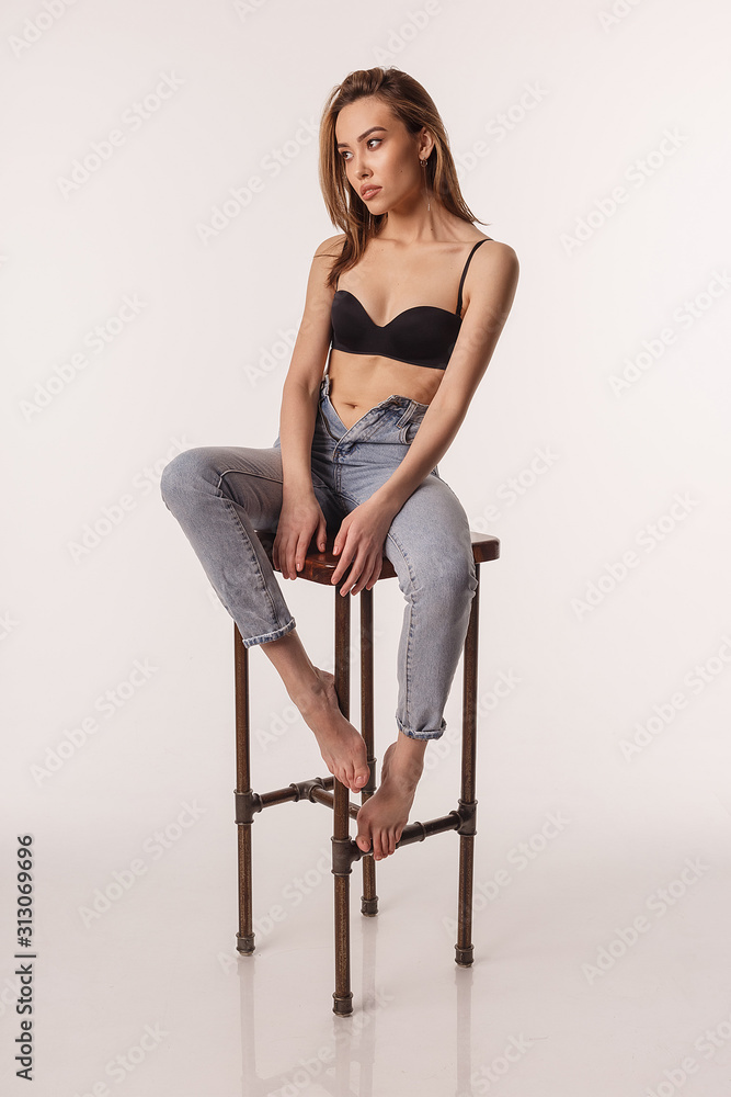 portrait of sexy asian woman with long hair posing in black lingerie and  blue jeans on