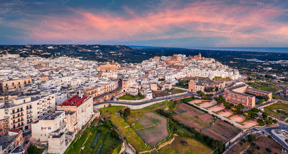 View from flying drone. Unbelievable spring sunrise in Ostuni town. Fantastic morning cityscape of Apulia, Italy, Europe. Traveling concept background..