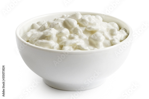 White ceramic bowl of chunky cottage cheese isolated on white.