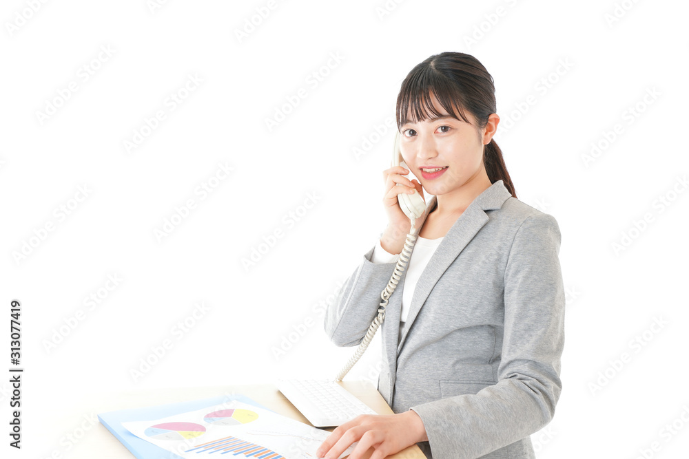 オフィスで固定電話を使う若いビジネスウーマン