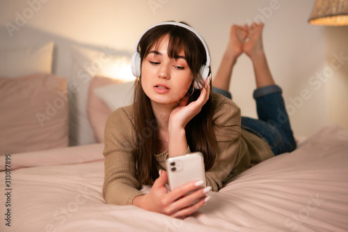 The girl with bluetooth headphones and a phone