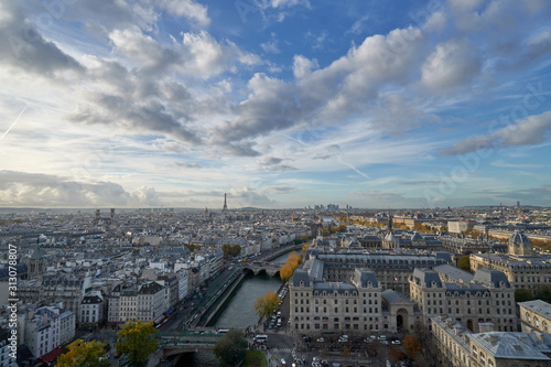 Aerial panorama of the Paris cityscape with Eiffel Tower, river Seine and a beautiful cloudy sky over France.