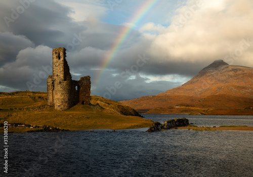 Ardvreck castle on Loch Assynt in Scotland with a beautiful rainbow