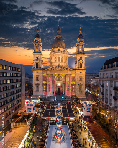 Budapest, Hungary - Aerial drone view of Europe's most beautiful Christmas market with the illuminated St.Stephen's Basilica, Ice rink, Christmas tree and clear blue sky .at dusk photo