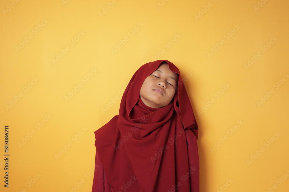 Asian Muslim Teenage Girl Wearing Hijab Looks Tired and Sleepy Asian Muslim Teenage Girl Wearing Hijab Looks Tired and Sleepy
