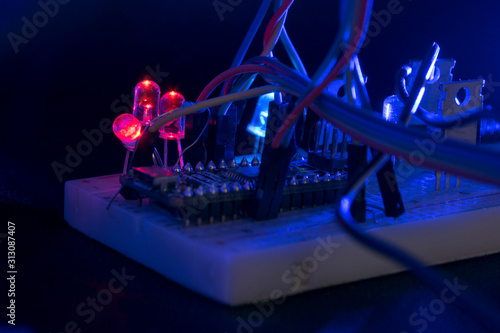 breadboard arduino nano prototyping board transistors resistors LEDs red and blue in glow in the dark on black skin