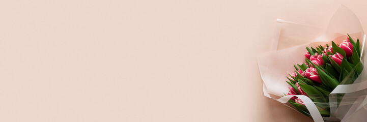 Banner 3:1. Bouquet of pink tulips on pink background. Valentines day or Mothers day celebration concept. Top view. Flat lay. Copy space