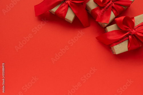Gift boxes wrapped on red ribbons on red background. Valentines day or Mothers day celebration concept. Top view. copy space