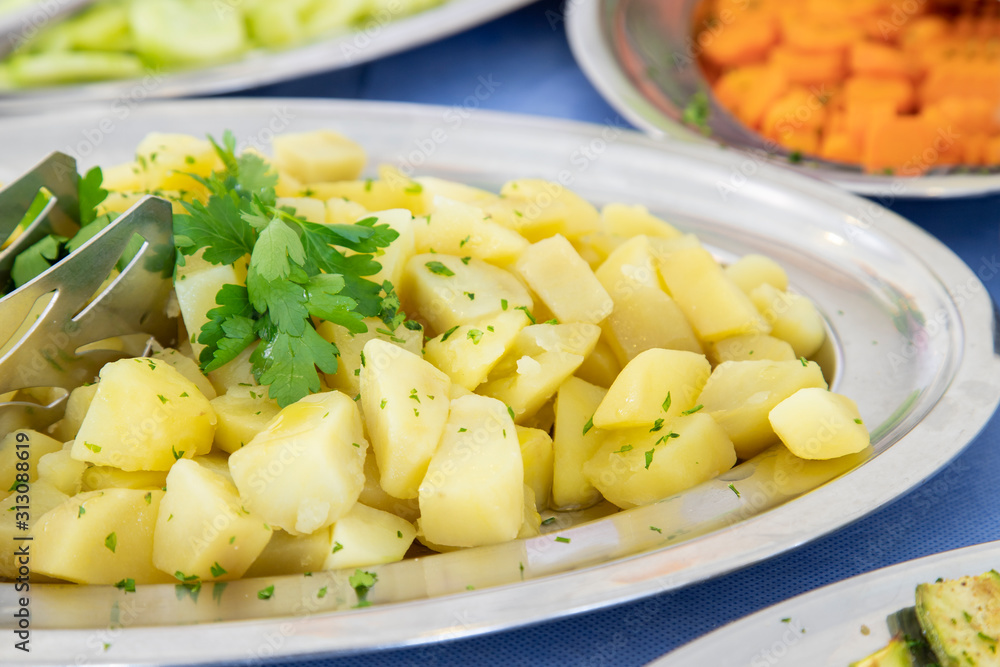 Breakfast buffet in hotel restaurant. Tray of boiled potatoes with parsley Breakfast buffet in hotel restaurant. Tray of boiled potatoes with parsley