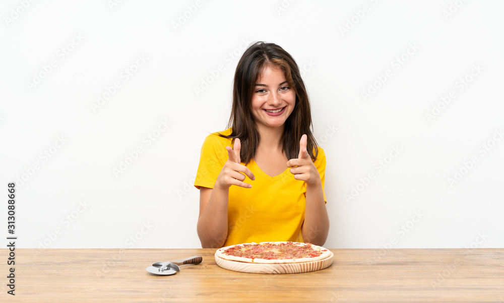 Caucasian girl with a pizza points finger at you Caucasian girl with a pizza points finger at you