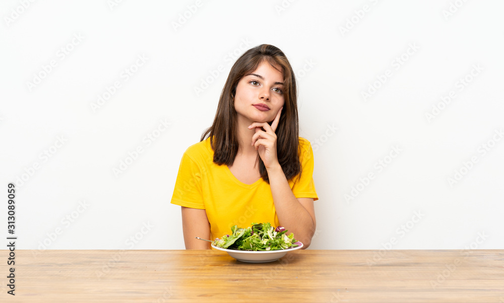 Caucasian girl with salad thinking an idea Caucasian girl with salad thinking an idea