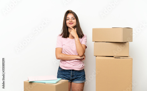 Young girl moving in new home among boxes laughing