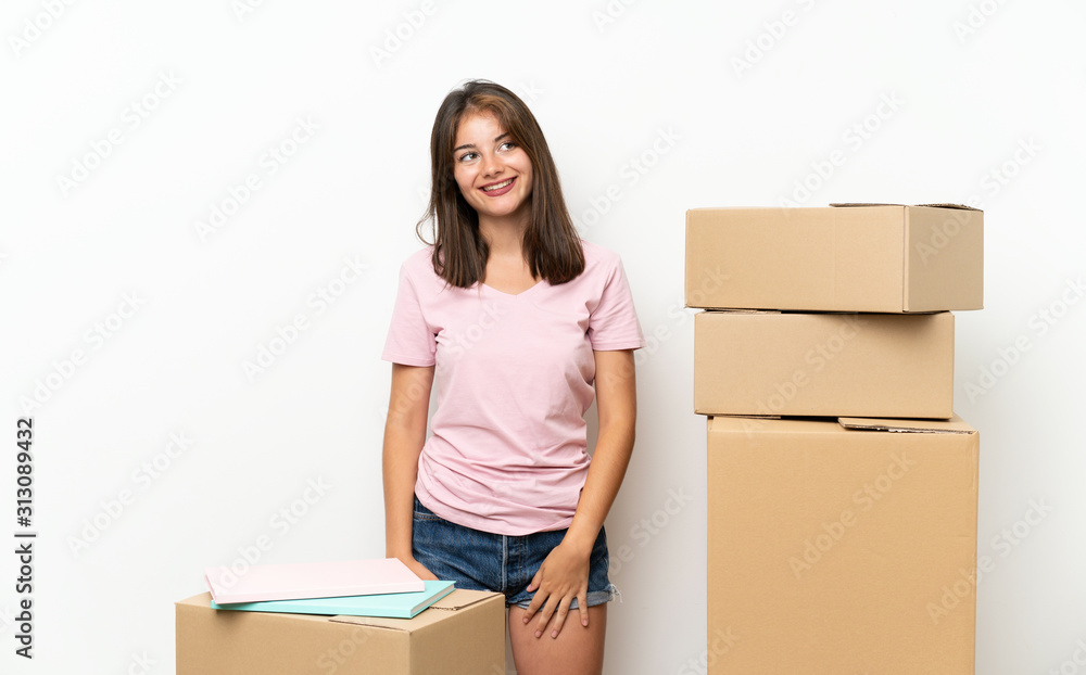 Young girl moving in new home among boxes laughing and looking up Young girl moving in new home among boxes laughing and looking up