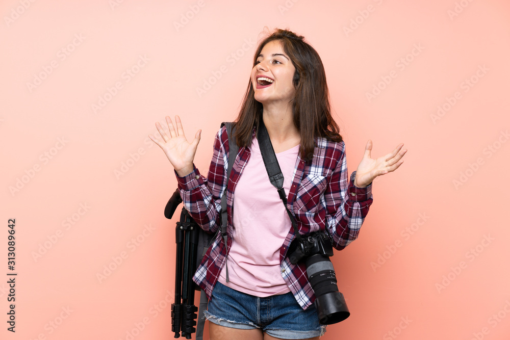 Young photographer girl over isolated pink background with surprise facial expression Young photographer girl over isolated pink background with surprise facial expression
