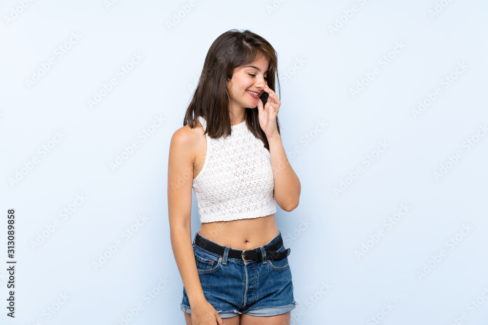 Young woman over isolated blue background smiling a lot Young woman over isolated blue background smiling a lot