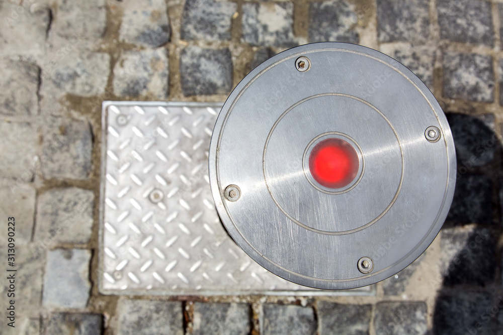 electrician hydro bollard gray metal with red lamp top view on stone tiles.