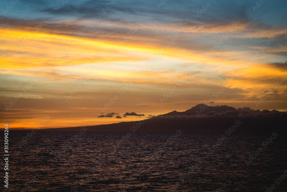 Colorful view of Cebu Philippines coastline with colorful sky, clouds and mountain