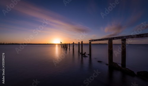Broken jetty leading into the sea at sunset  © Bradley