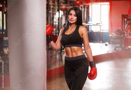 Young women boxer stending near boxing bag in the gym © VlaDee