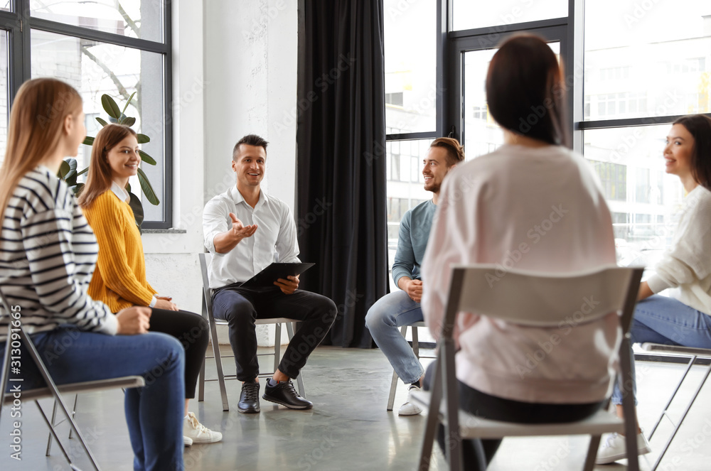 Psychotherapist working with patients in group therapy session indoors