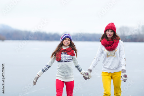 Family mother with her daughter enjoying in ice skating. Outdoor activities on weekends. The joy of missing out.