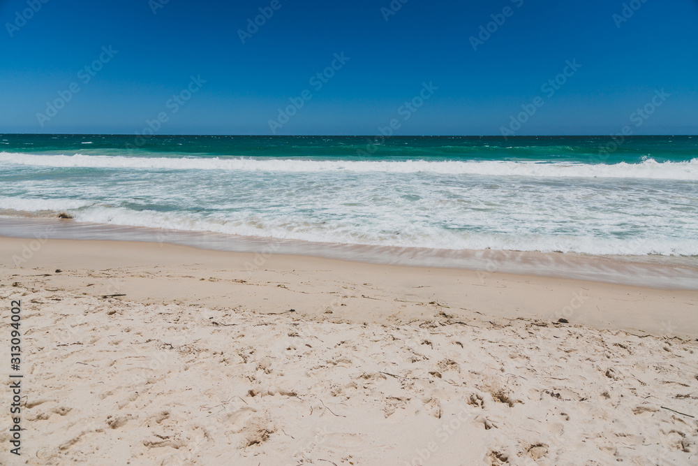 Fototapeta premium view of Scarborough beach, one of the most popular beaches near Perth on the Indian Ocean, with intense turquoise water and ships in the distance