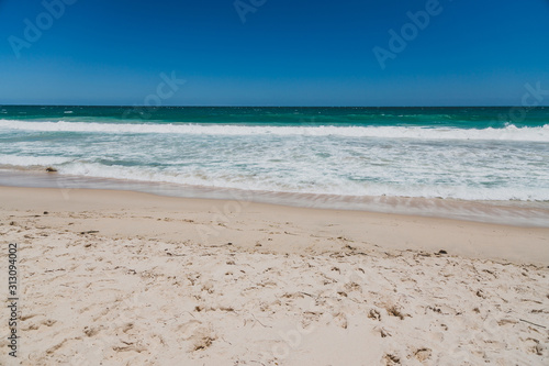 Fototapeta Naklejka Na Ścianę i Meble -  view of Scarborough beach, one of the most popular beaches near Perth on the Indian Ocean, with intense turquoise water and ships in the distance