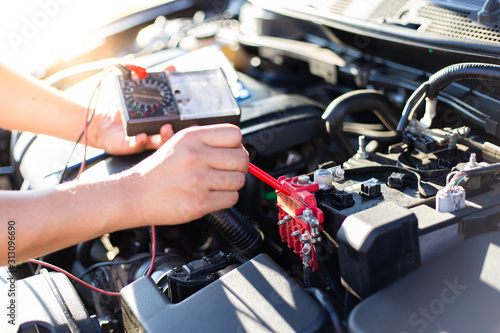 Auto repair technician has inspected the condition of the engine using ammeter, Car repair service concept.