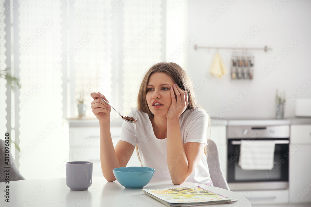 Sleepy young woman eating breakfast at home in morning Sleepy young woman eating breakfast at home in morning
