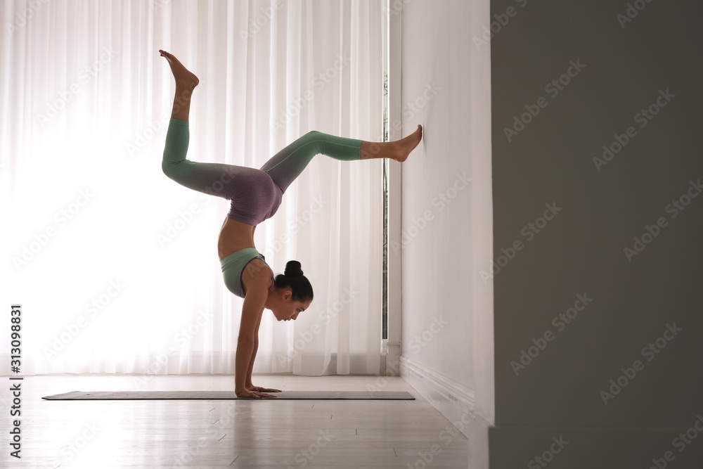 Woman practicing downward facing tree asana in yoga studio. Adho mukha  vrksasana pose Stock Photo