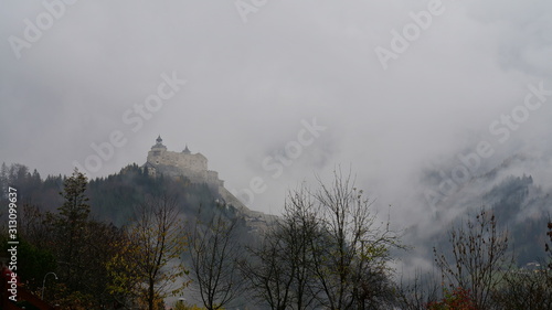 Medieval castle in fog on top of a mountain in Austria, Europe.