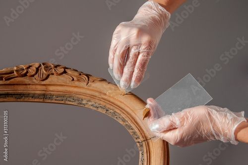 фотографія renovation armchair by filling cracks with a hardening compound to seal them on chair's backrest