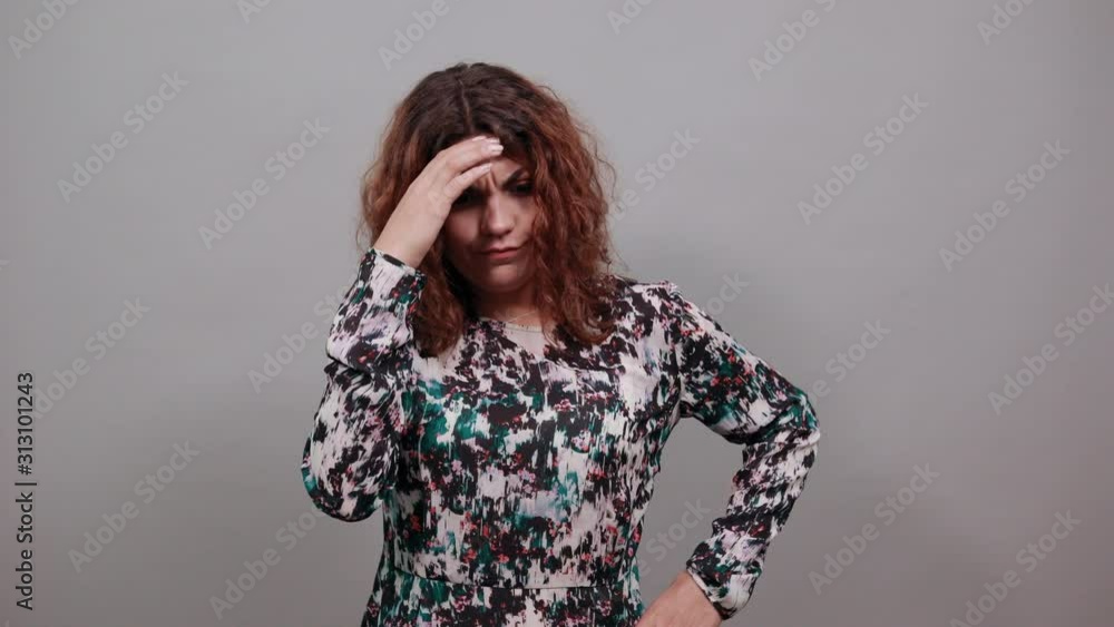Unhappy charming young lady over isolated gray background in fashion shirt looking scared, spread hands, keeping hand on head. People emotions. Lifestyle concept Unhappy charming young lady over isolated gray background in fashion shirt looking scared, spread hands, keeping hand on head. People emotions. Lifestyle concept
