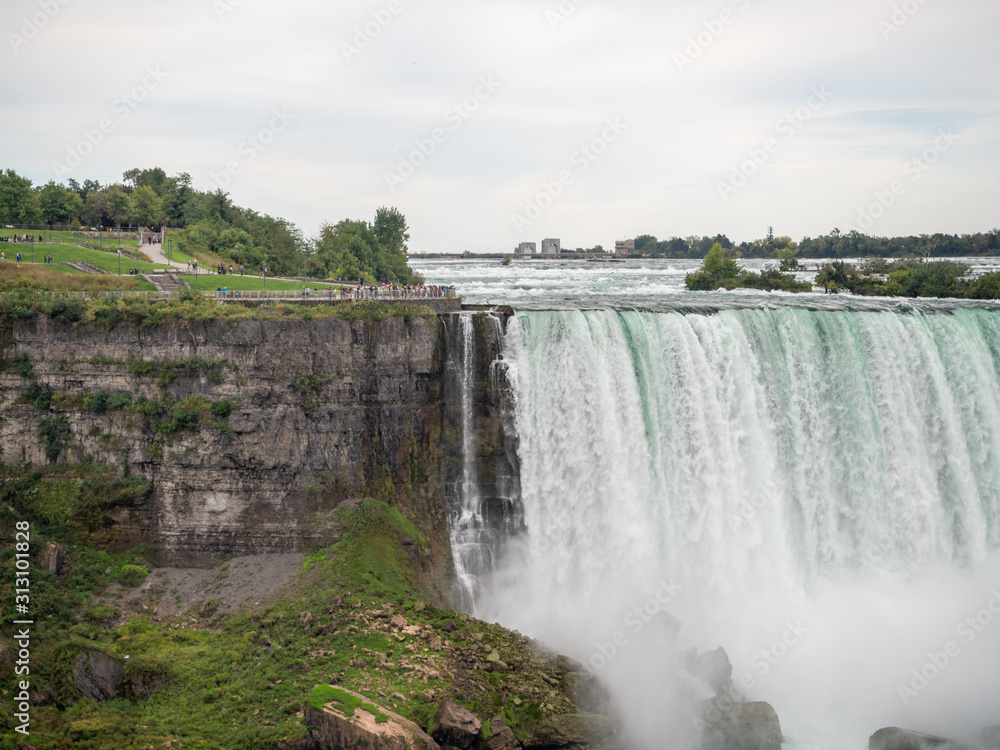 Niagara Falls, New York state, United States of America and Canada - edge of Niagara falls, town from American and Canadian city side, falling water and mist