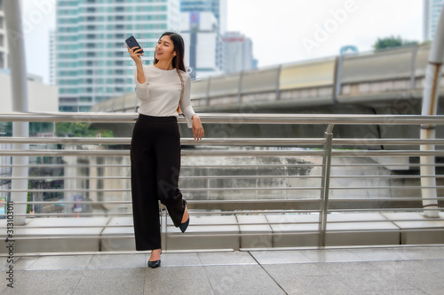 young business woman  looking at mobile phone in the street