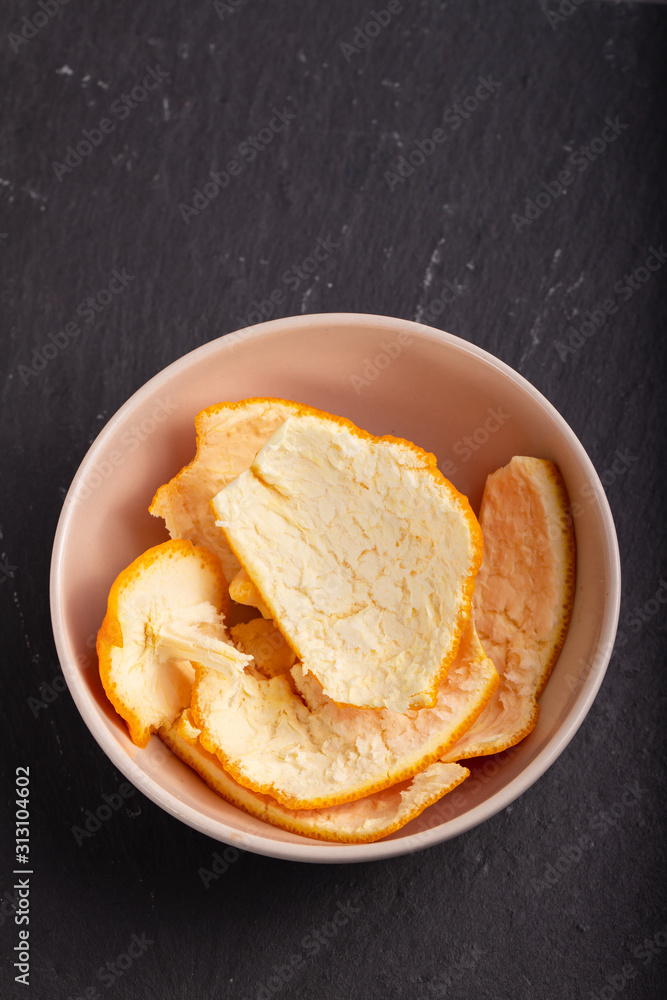 orange peel in small bowl on ceramic background orange peel in small bowl on ceramic background