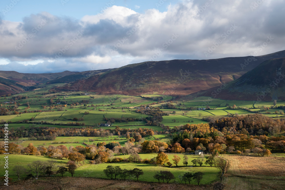 Beautiful Autumn Fall landscape view along valley towards Mellbreak and Grasmoor in Lake District with vibrant epic lighting in late afternoon