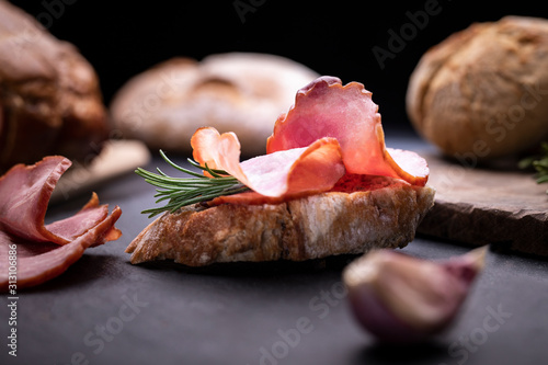 Appetizing sandwich made of freshly baked, crunchy bread with Krakowska dried sausage. Traditional cold cuts. photo