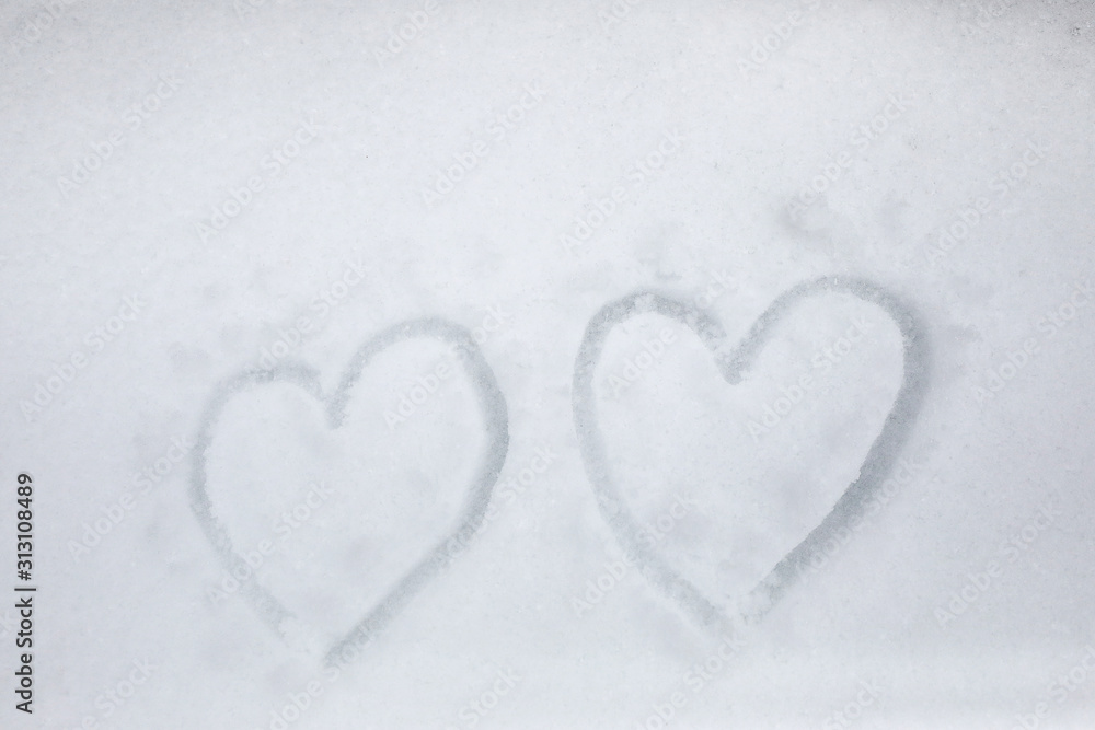 Two heart on the fresh white snow background. Love or valentines day concept.