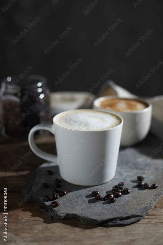 Hot coffee cup and coffee beans on wooden table.. Hot coffee cup and coffee beans on wooden table..