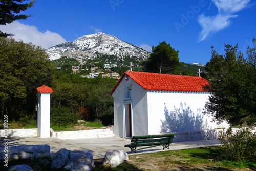 Winter photo of mount Parnitha covered with slight snow and deep blue cloudy sky on a sunny morning photo