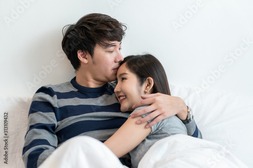 wonderful young couple hug and enjoy life together and smiling tender couple hugging in bed in the morning