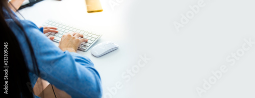 Business woman use computer for online shopping and typing on keyboard at Home office with white cup of coffee
