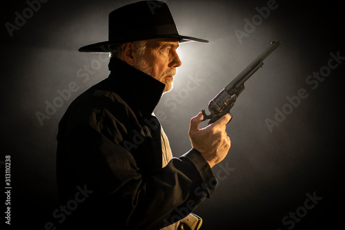 old west gun fighter looking at someone and ready for a fight photo