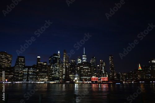 New york skyline from brooklyn at night with water reflection